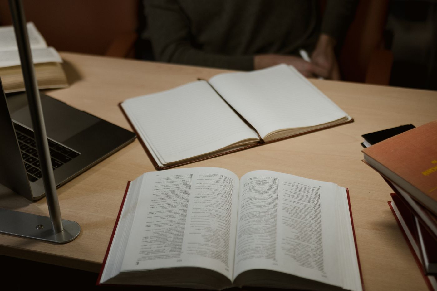 Open books and papers spread across a wooden desk